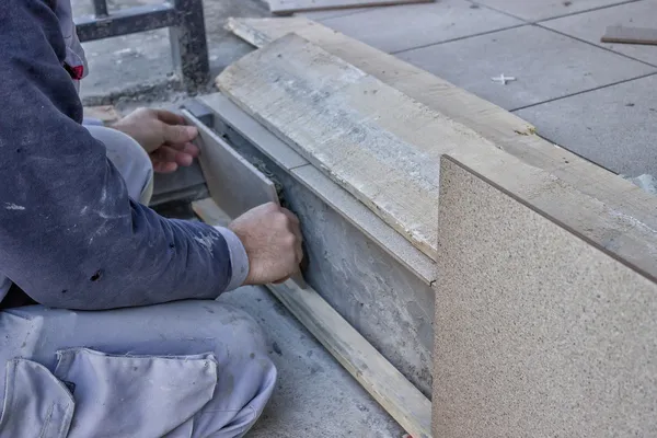 Trabalhador instalar telha cerâmica escadas — Fotografia de Stock