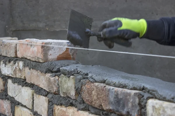 Construir una pared de ladrillo, albañilería que extiende una junta de la cama 2 — Foto de Stock