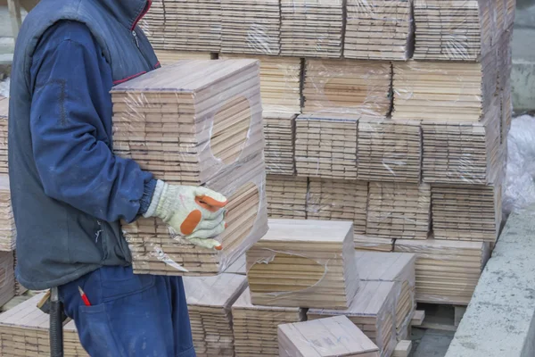 Pracovník nese balíčky bukového dřeva profilů 3 — Stock fotografie