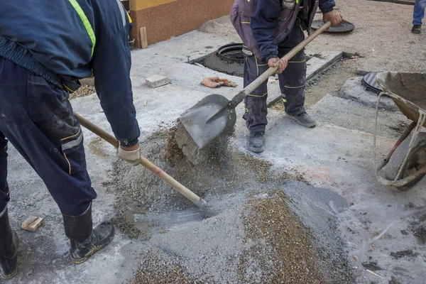 Worker is mixing the cement by hand — Stock Photo, Image