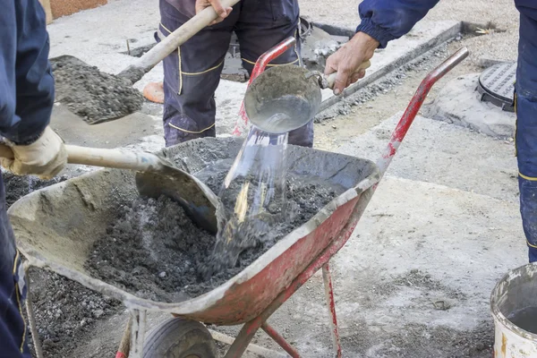 Arbeiter mischen den Zement von Hand in Schubkarre 2 — Stockfoto