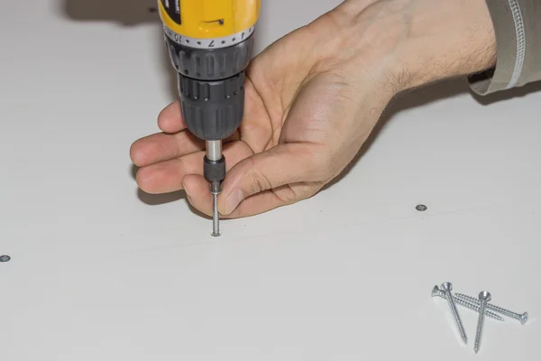 Using a cordless drill to screwing kitchen cabinet — Stock Photo, Image