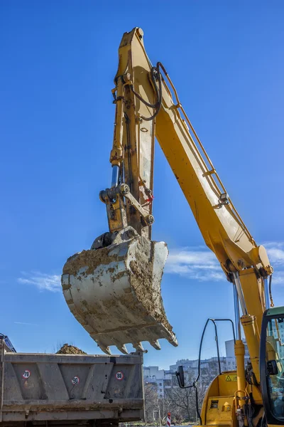 Excavator arm and dumper truck — Stock Photo, Image