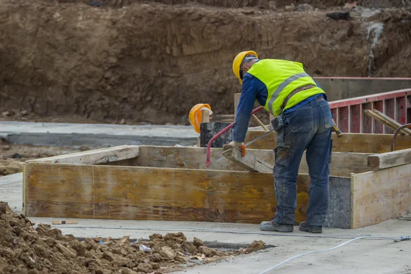 Builder worker cutting wood beam — Stock Photo, Image