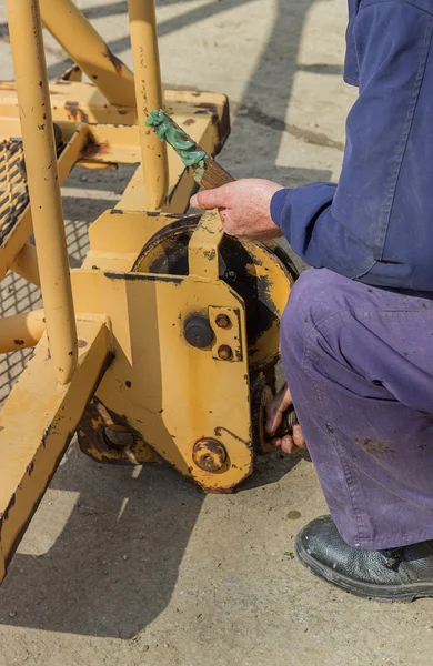 Trabajadores de la construcción engrasando partes de la grúa — Foto de Stock