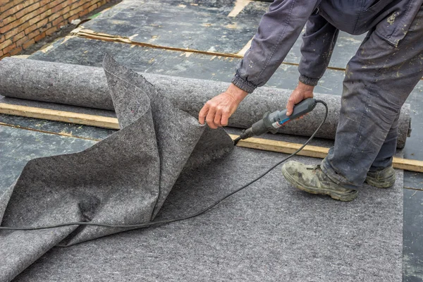 Pracovník řezání izolační materiál pro suterénní stěny — Stock fotografie