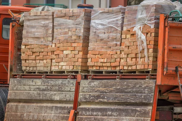 Clay building bricks delivered to the job site in pallets — Stock Photo, Image