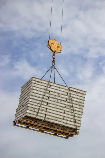 Lifting pallet with formwork elements by crane — Stock Photo, Image