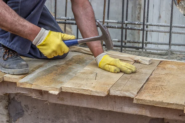 Bouwer handen een nagel hameren in een plank 2 — Stockfoto