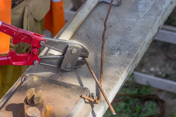 Cutting rebar with bolt cutters — Stock Photo, Image