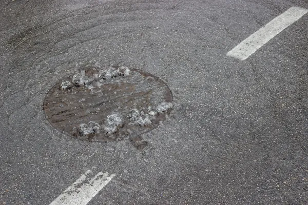 L'eau bouillonne à travers le couvercle de trou d'homme et les égouts — Photo