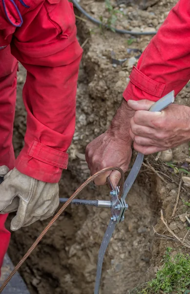 Temel toprak elektrotları için kelepçeleri bağlayan işçiler — Stok fotoğraf