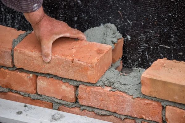 Bauarbeiter mit Hand, der Ziegelmauer baut — Stockfoto