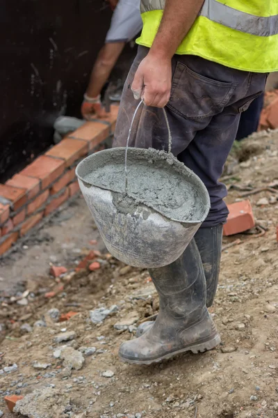 Worker bringing a bucket of mortar — Stock Photo, Image