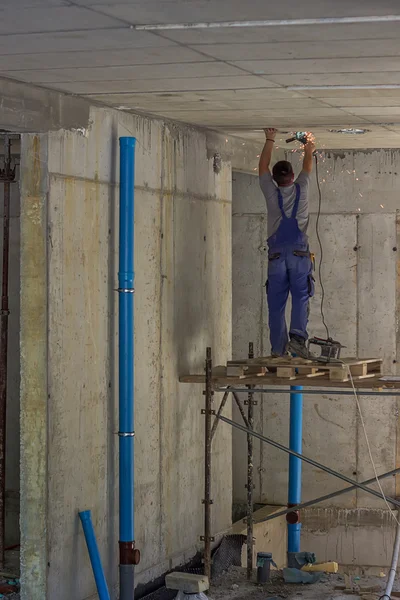 Trabalhador que instala os tubos de esgoto em novo edifício — Fotografia de Stock