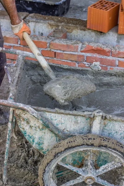 2 колеса бетона тележки с бетоном и лопатой — стоковое фото