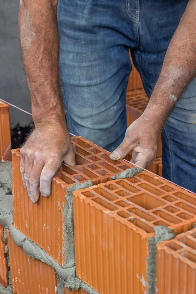 Trabalhador da construção civil que estabelece bloco de argila oca — Fotografia de Stock