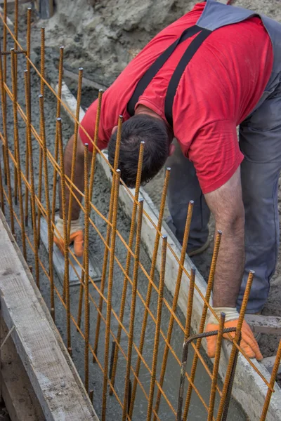 Construction worker smooth fresh concrete with trowel in a ditch — Stock Photo, Image