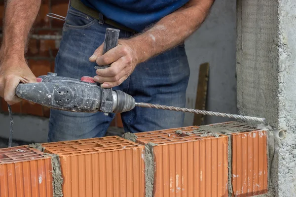 Trabajador de la construcción utiliza taladro para hacer agujeros en hormigón 2 — Foto de Stock