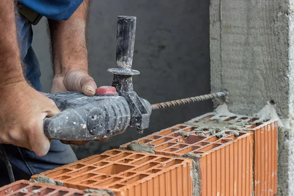 Construction worker uses drill to make holes in concrete for for — Stock Photo, Image