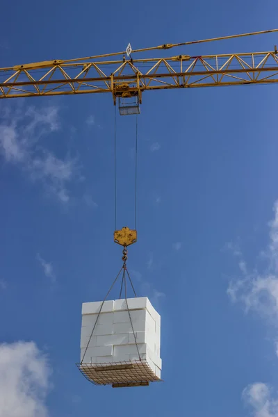 Crane lifting stacked white styrofoam sheets — Stock Photo, Image