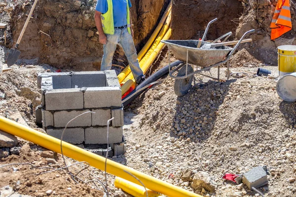 Robotnik Budowlany Pracujący Okopach Instalujący Podziemną Komunikację Dla Nowego Budynku — Zdjęcie stockowe
