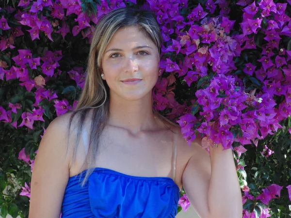 Schöne junge Frau umgeben von den violetten Blumen. — Stockfoto