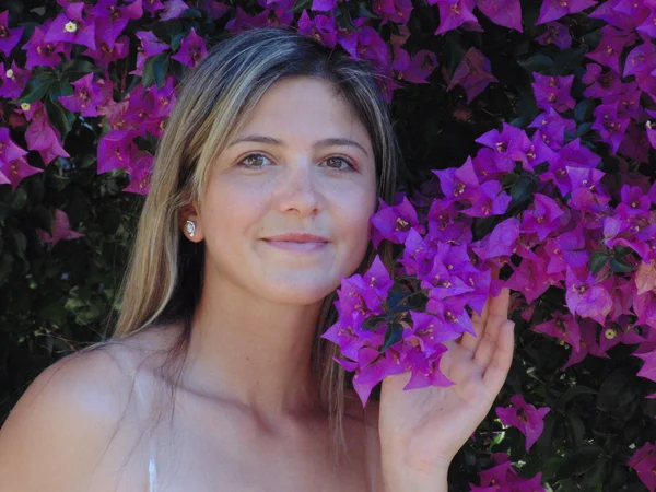 Güzel bir genç kadın ve mor çiçekler. — Stok fotoğraf