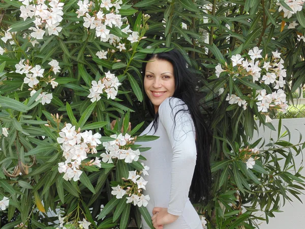 Bardzo piękna kobieta i wielu białych kwiatów. — Zdjęcie stockowe