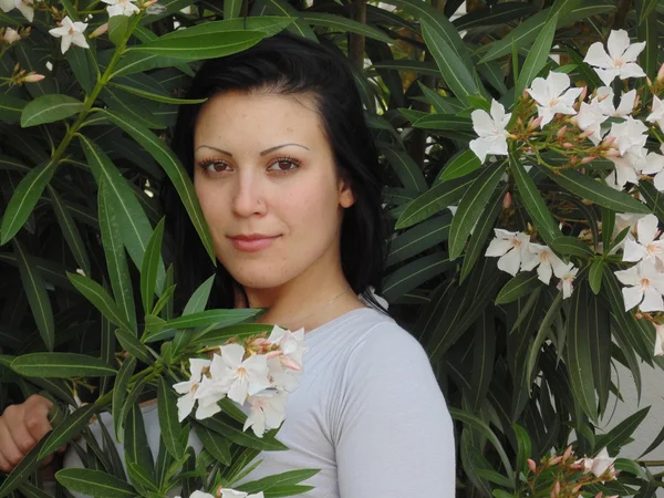 Mujer muy hermosa cerca de flores . — Foto de Stock