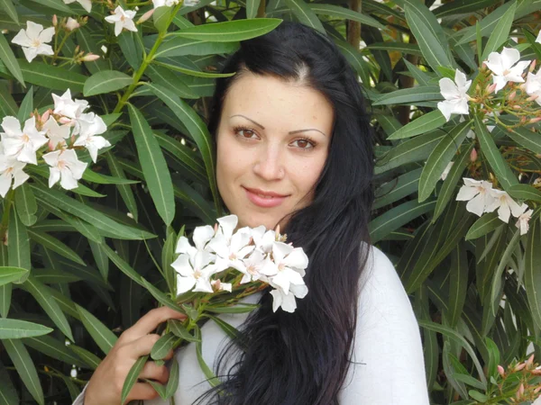 Zeer mooie vrouw in de buurt van de witte bloemen. — Stockfoto
