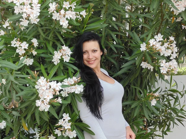 Mulher muito bonita e flores brancas . — Fotografia de Stock