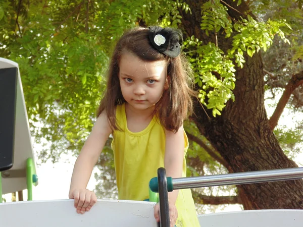 Gyönyörű kicsi lány játszik a dián. — Stock Fotó