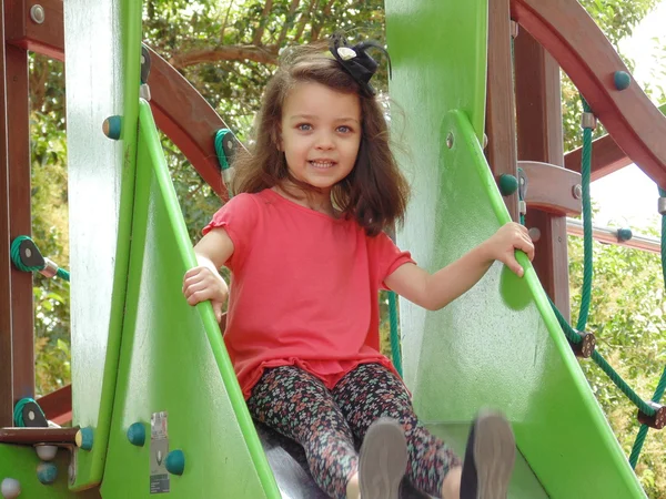 Little girl on the slide in the park.