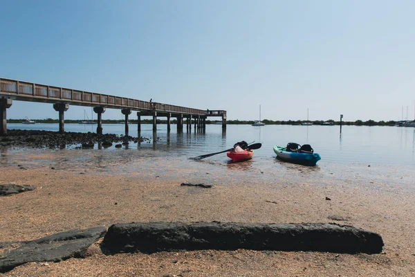 Kayaks in water next to fishing dock at Lighthouse Park in Saint Augustine, Florida