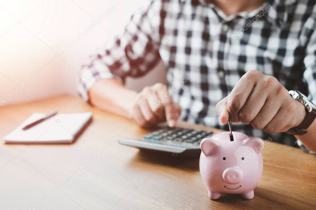 image of man hand putting coins in pink piggy bank for account save money. Planning step up, saving money for future plan, retirement fund. Business investment-finance accounting concept.