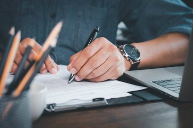 Hand 'in kapanışı anket ya da evrak anketi içeren kalem kullanarak şirket kişisel bilgi formu kontrol listesi belgesini doldurma sorusu.