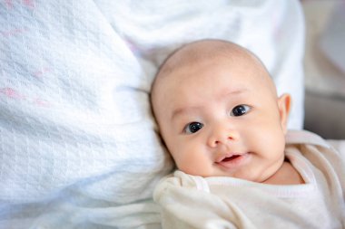 Gülümseyen gülen yüzlü sevimli yeni doğmuş bebek. Hayatın ilk gününde yeni doğmuş masum bir çocuk. Anneler günü konsepti.