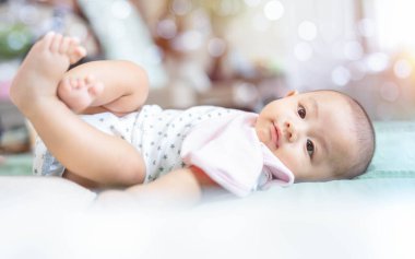 Sevimli, Asyalı yeni doğmuş bebek yatakta yatıyor. Bebeğim kameraya bak ve gülümse. Hayatın ilk gününde yeni doğmuş masum bir çocuk. Anneler günü konsepti.