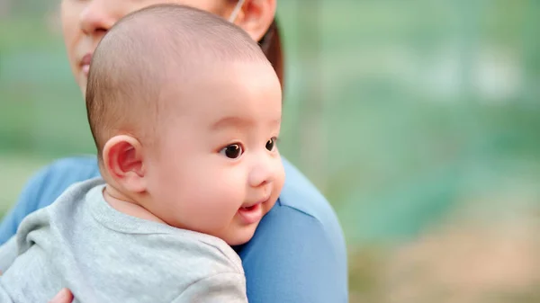 かわいい 笑顔の幸せな顔をした新生児アジアの赤ちゃん 家族の幸せ アジアの若い母親が愛を運んで世話をしています 人生の最初の日にほとんど無実の新しい幼児 母の日のコンセプト ロイヤリティフリーのストック画像