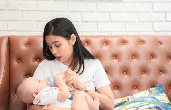 可爱的亚洲新生男婴 亚洲母亲用爱心抚慰和拥抱婴儿 婴儿快乐地吃着纯真的牛奶 哺乳期婴儿概念 图库图片