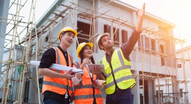 Diverse Team of Civil engineers manager, architects and foreman, worker. While use tablet inspect discuss meeting building project and pointing on construction site. Real estate and building concept.