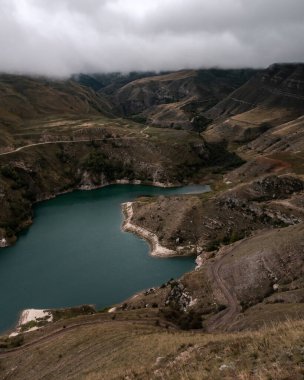 Bulutlu bir günde turkuaz suyu olan dağ gölü. Elbrus bölgesi