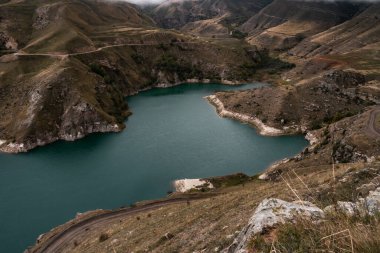 Bulutlu bir günde turkuaz suyu olan dağ gölü. Elbrus bölgesi
