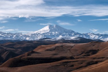 Büyük doğa sıradağları. Sonbahar tarlalarıyla Elbrus 'un inanılmaz perspektifi, mavi gökyüzü arkaplanı.