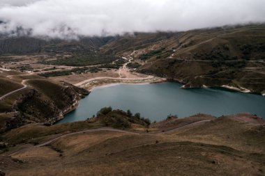 Bulutlu bir günde turkuaz suyu olan dağ gölü. Elbrus bölgesi