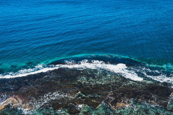 파도가 바위에 부딪치는 공중에서 위에서 바라본 해안선의 절벽의 놀라운 풍경이었습니다 — 스톡 사진