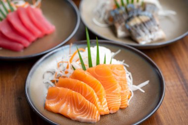 Taze somon dilimlenmiş sashimi, yanında da Çin yemeği, Japon yemeği.   