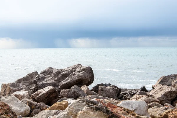 Felsen und Regen auf See. — Stockfoto