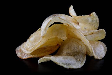 Siyah arka planda patates cipsi. Çıtır cipsler..